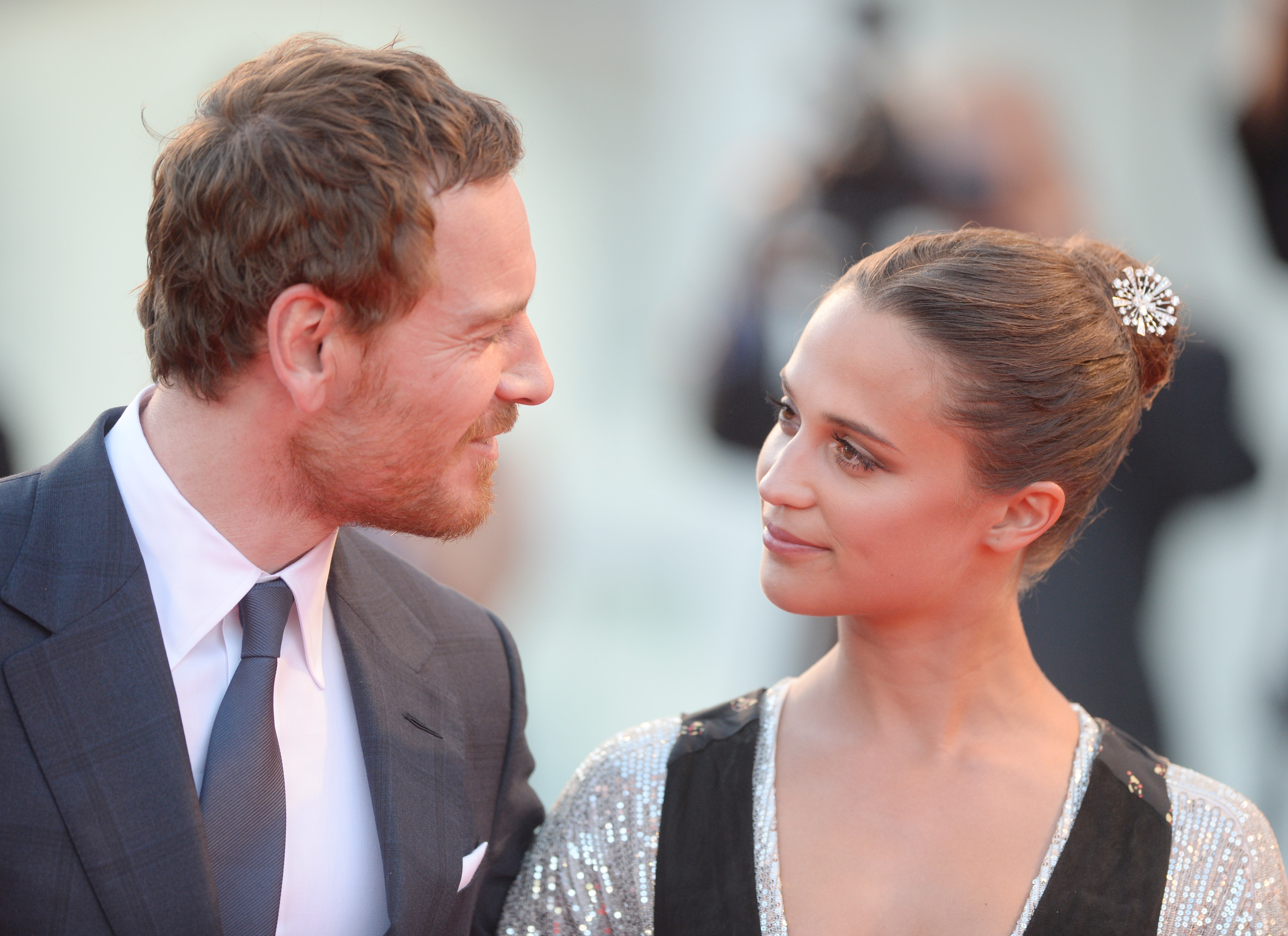Alicia Vikander cradles a baby while at an airport with husband Michael  Fassbender in Paris